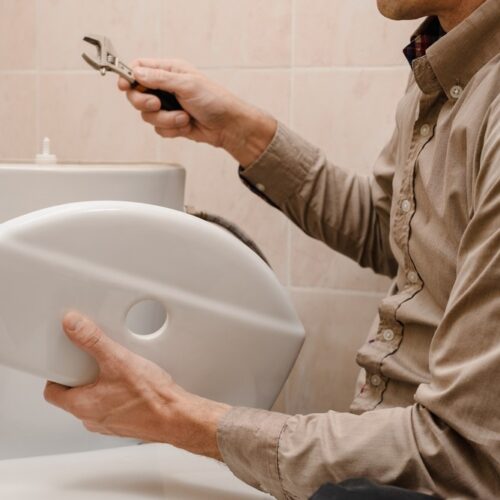 Plumber Repairing Toilet